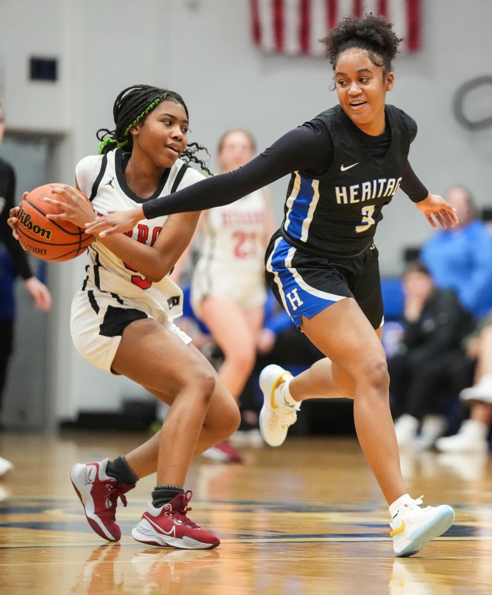 Herron Achaeans guard Maya Alexis (5) recovers the ball from Heritage Christian Eagles guard Mya Davis (3) on Tuesday, Jan. 30, 2024, during the game at Bishop Chatard High School in Indianapolis.