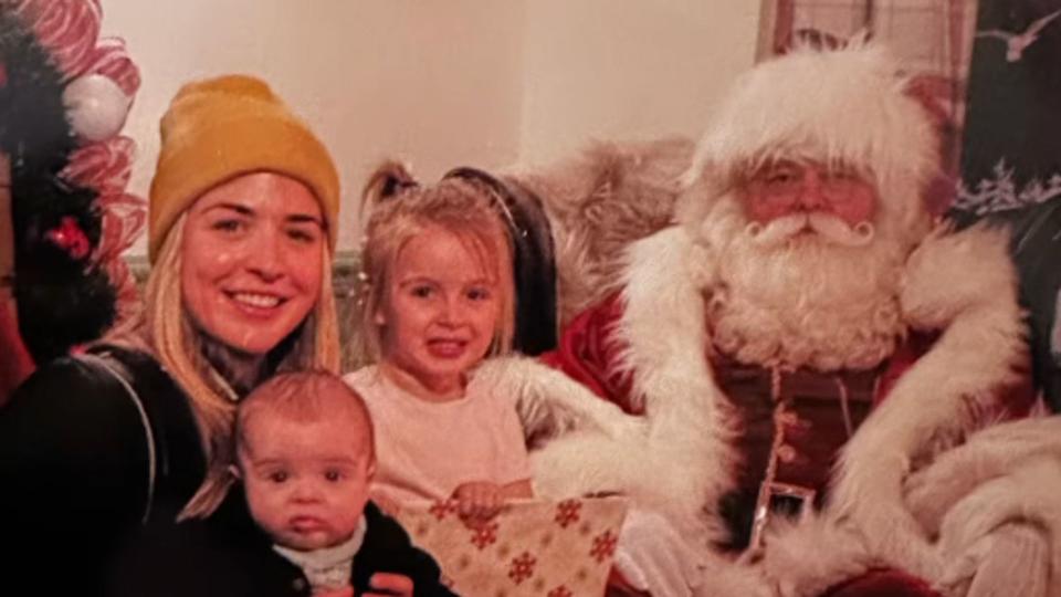 A family-of-three posing with Santa Claus