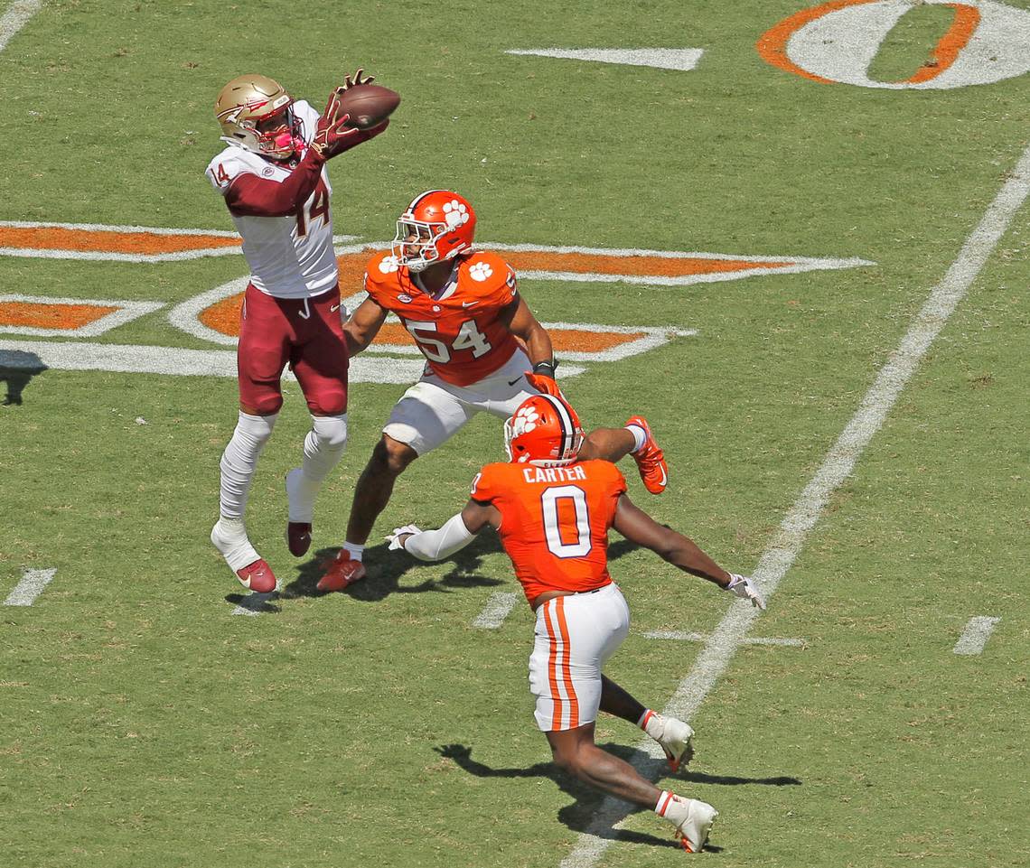 Florida State wide receiver Johnny Wilson (14) makes a catch over Clemson linebacker Jeremiah Trotter Jr. (54) and Clemson linebacker Barrett Carter (0) during first-half action in Clemson, S.C. on Saturday, Sept. 23, 2023.