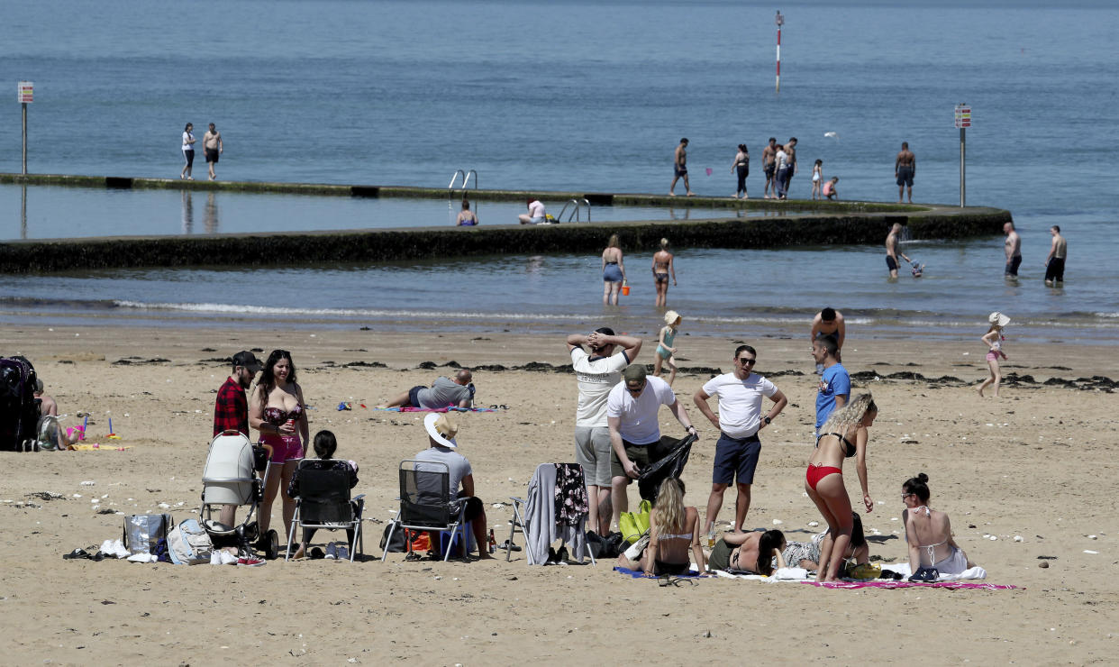People settle to enjoy the good weather on the beach in Margate, Kent, after the introduction of measures to bring the country out of lockdown, in Margate, England, Tuesday May 19, 2020. (Gareth Fuller/PA via AP)