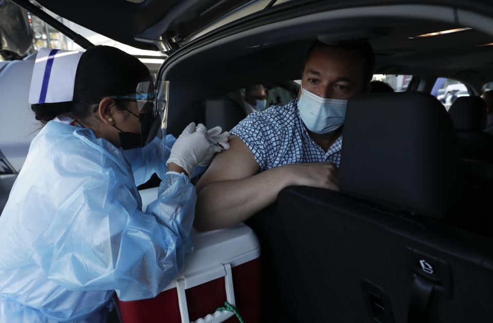 Un hombre recibe la vacuna de AstraZeneca contra el COVID-19 el jueves 22 de abril de 2021 en el estacionamiento del estadio Rommel Fernández, en Ciudad de Panamá. (AP Foto/Arnulfo Franco)