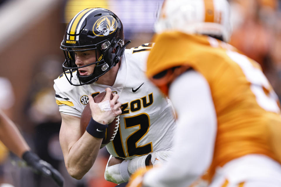 Missouri quarterback Brady Cook (12) runs for yardage during the first half of an NCAA college football game against Tennessee Saturday, Nov. 12, 2022, in Knoxville, Tenn. (AP Photo/Wade Payne)