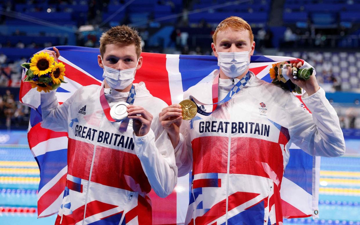 Team GB swimmers Duncan Scott, left, and Tom Dean, right, pose with their medals - Photo by Odd ANDERSEN / AFP