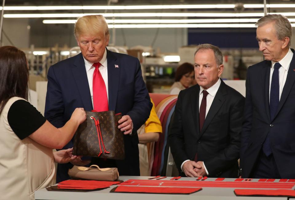 U.S. President Donald Trump holds a purse as he visits the Louis Vuitton Rochambeau Ranch leather workshop in Texas.