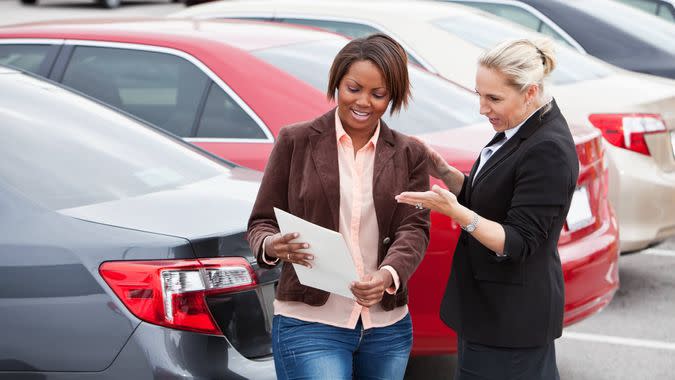 Woman shopping for a new car, with a saleswoman.