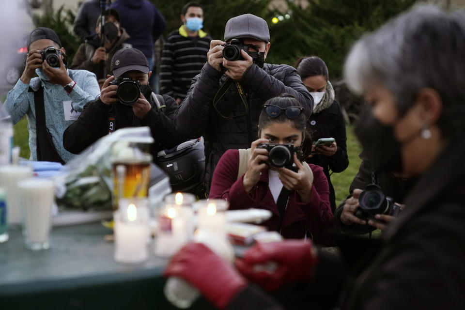 Journalists cover a vigil in honor of news photographer Margarito Martinez, Friday, Jan. 21, 2022, in Tijuana, Mexico. Martinez, a Tijuana-based photojournalist who specialized in covering gritty crime scenes in this border city, was shot as he left his home on Jan 17. (AP Photo/Gregory Bull)