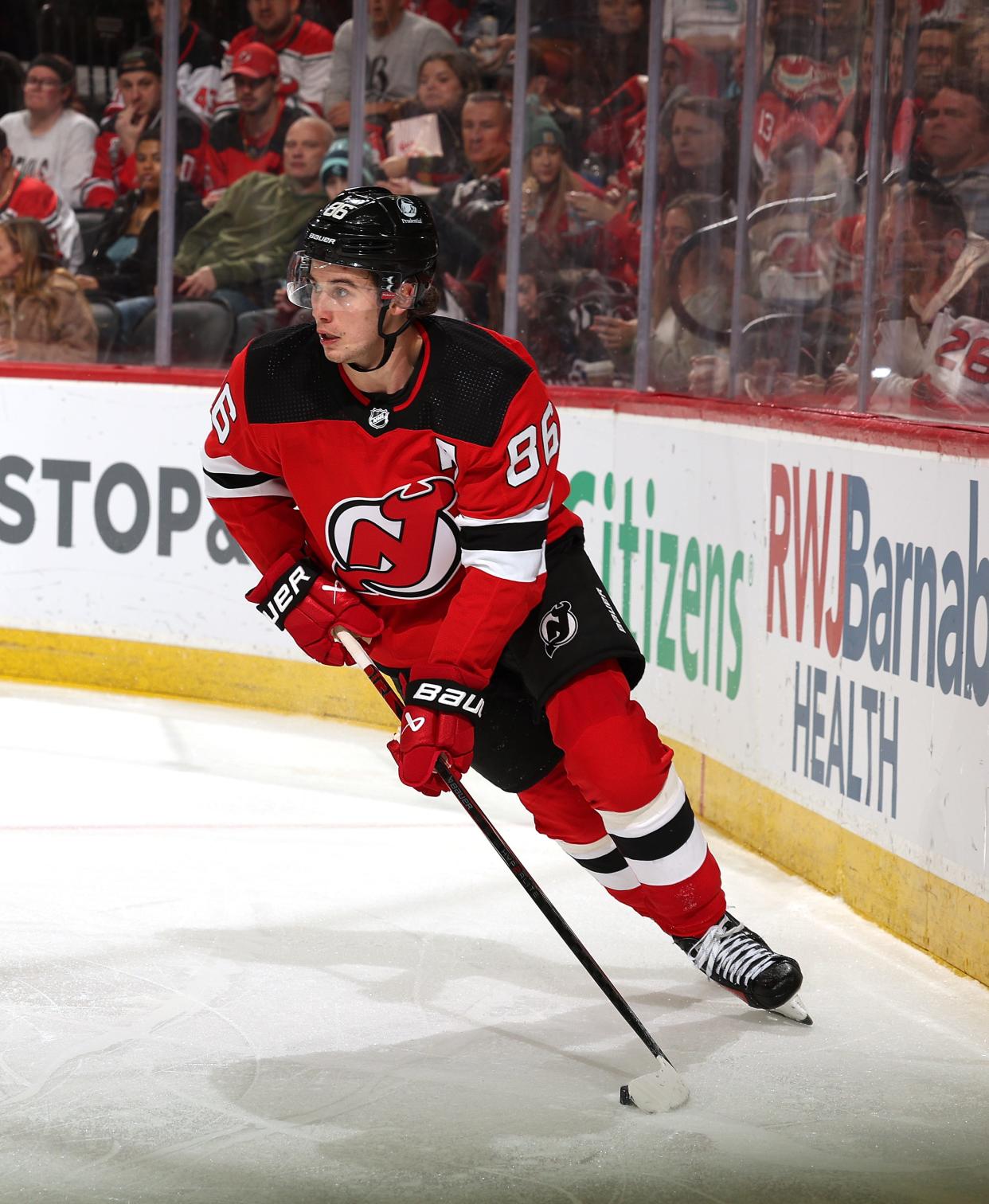 NEWARK, NEW JERSEY - FEBRUARY 12: Jack Hughes #86 of the New Jersey Devils takes the puck during the second against the Seattle Kraken at Prudential Center on February 12, 2024 in Newark, New Jersey.