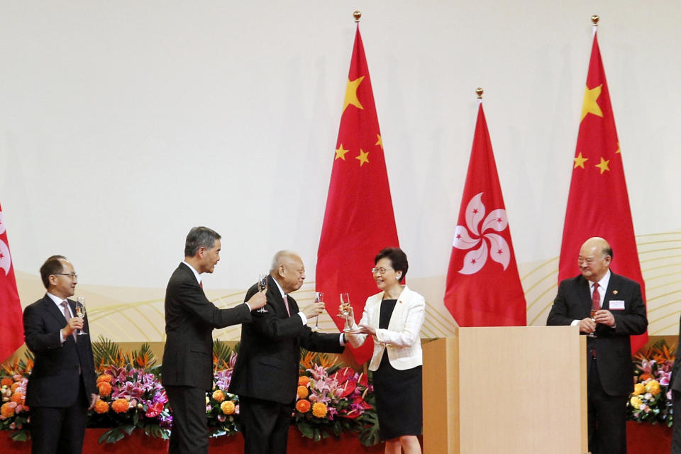 Hong Kong Chief Executive Carrie Lam, second right, toasts with former Chief Executives Tung Chee-hwa, third from left, and Leung Chun-ying, second from left, during a ceremony to mark the anniversary of the handover of Hong Kong to China, in Hong Kong Monday, July 1, 2019. The Hong Kong government marked the 22nd anniversary of the former British colony's return to China on Monday, as police faced off with protesters outside the venue. (Jacky Cheung/HK01 via AP)