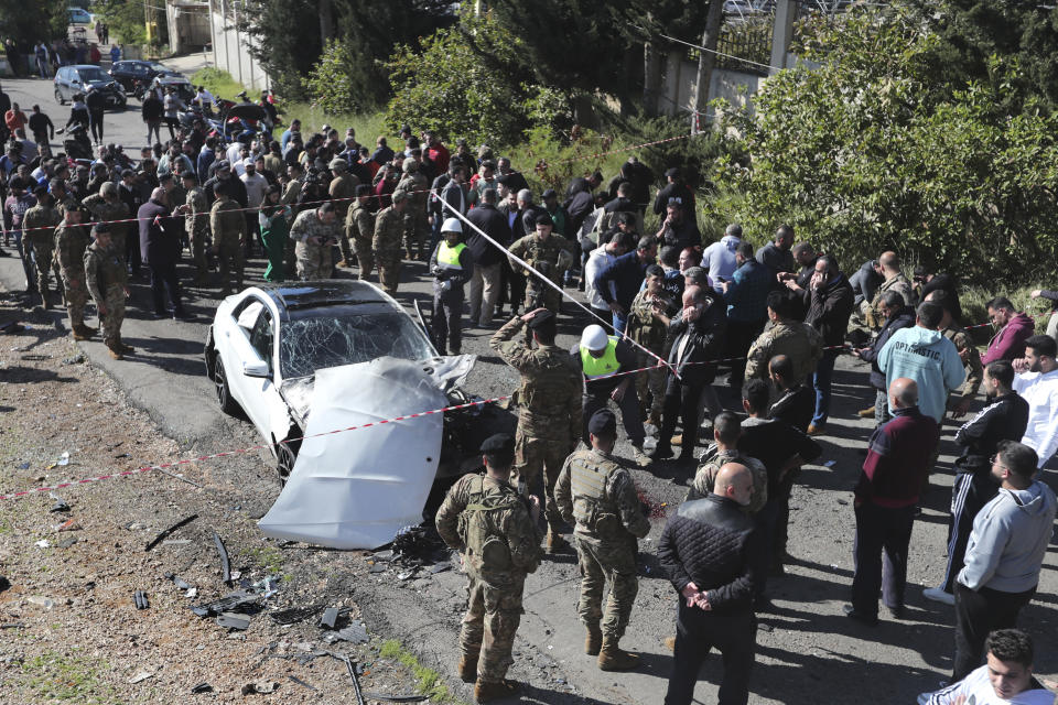 Lebanese army soldiers gather around a damaged car near the coastal town of Jadra, south Lebanon, Saturday, Feb. 10, 2024. An apparent Israeli drone strike hit a car near Lebanon's southern port city of Sidon Saturday killing at least two people and wounded others, security officials said. (AP Photo/Mohammed Zaatari)