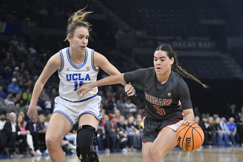 Washington State guard Charlisse Leger-Walker handles the ball against UCLA forward Emily Bessoir during the first half of an NCAA college basketball game in the finals of the Pac-12 women's tournament, Sunday, March 5, 2023, in Las Vegas. (AP Photo/David Becker)