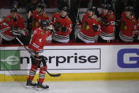 Chicago Blackhawks' Seth Jones (4) celebrates with teammates at the bench after scoring a goal during the first period of an NHL hockey game against the Calgary Flames Tuesday, March 26, 2024, in Chicago. (AP Photo/Paul Beaty)