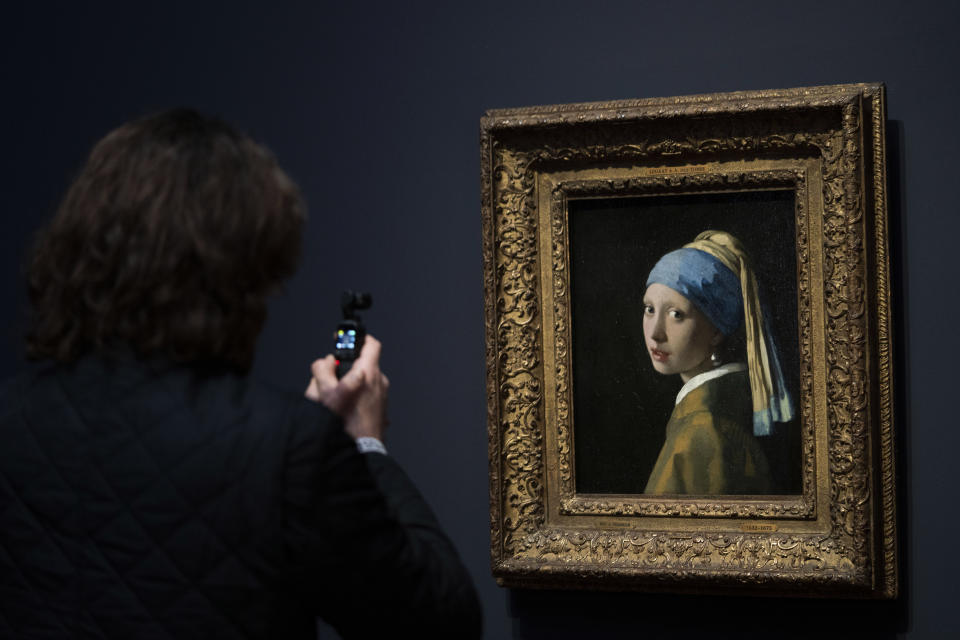 A journalist takes images of Girl with a Pearl Earring during a press preview of the Vermeer exhibit at Amsterdam's Rijksmuseum, Monday, Feb. 6, 2023, which unveils its blockbuster exhibition of 28 paintings by 17th-century Dutch master Johannes Vermeer drawn from galleries around the world. (AP Photo/Peter Dejong)