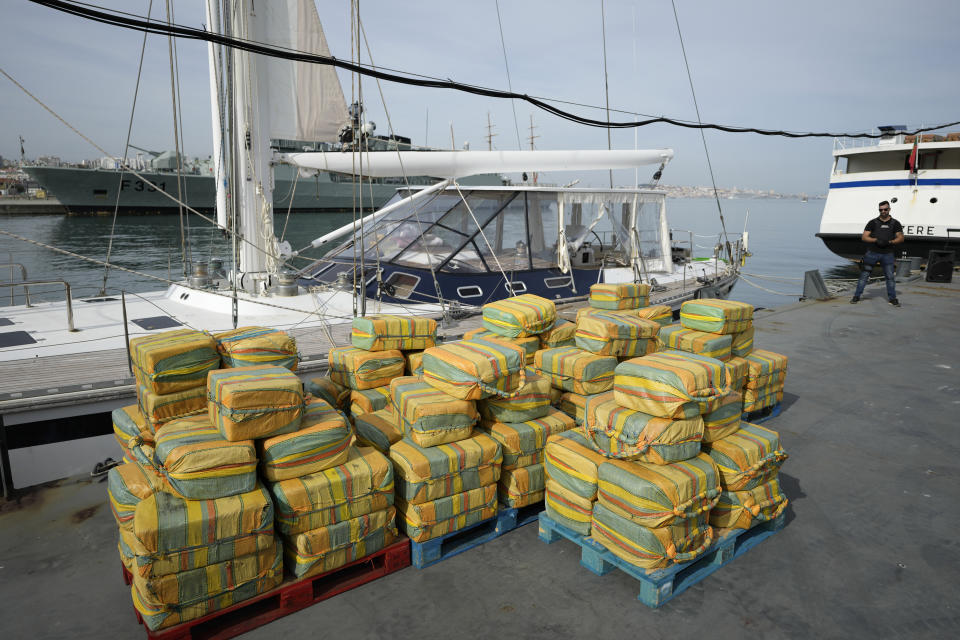 Bales of cocaine weighting some 5,2 tons and a seized yacht are displayed for the media at a Portuguese Navy base in Almada, south of Lisbon, Monday, Oct. 18, 2021. Portuguese police said Monday the seizure was the largest in Europe in recent years and the biggest in Portugal for 15 years. Police localized and intercepted the 24-meter (79-foot) yacht at sea. The operation involved police from Portugal, Spain, the Drug Enforcement Agency in the United States and the United Kingdom's National Crime Agency. (AP Photo/Armando Franca)