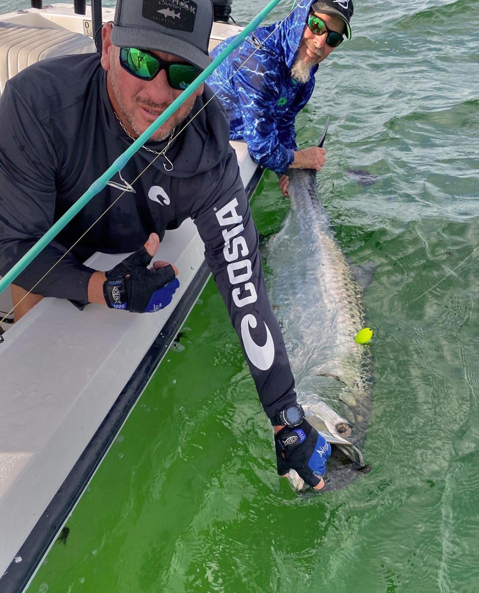 Clay Ritchings of Lakeland, right, and Capt. John Gunter of Palmetto, show off a 150-pound class tarpon Ritchings caught on a live pass crab while fishing in lower Tampa Bay this week.