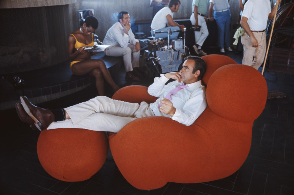 Actress Trina Parks and Scottish actor Sean Connery relax between takes on the set of the James Bond film 'Diamonds Are Forever', USA, 1971. They are on location at the Elrod House in Palm Springs, California, and Connery is sitting in a 1969 Gaetano Pesce 'Up' chair. (Photo by Anwar Hussein/Getty Images)