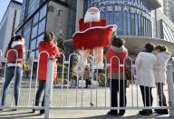 Women take pictures in front of a Santa Claus figure outside a shopping mall ahead of Christmas in Taiyuan, Shanxi province, December 11, 2013. REUTERS/Jon Woo (CHINA - Tags: SOCIETY) CHINA OUT. NO COMMERCIAL OR EDITORIAL SALES IN CHINA