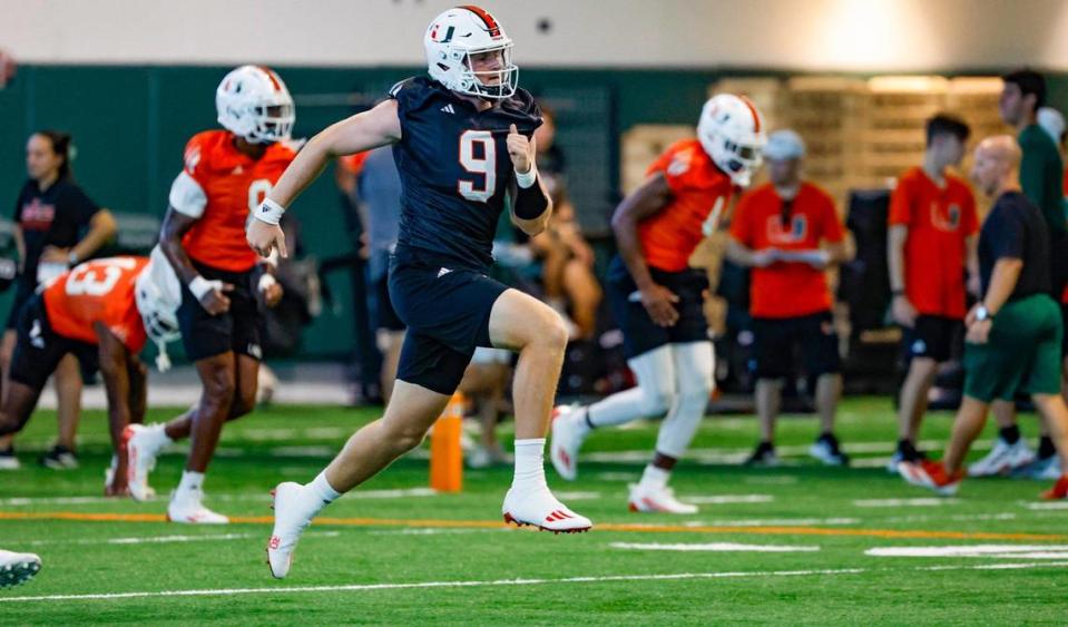 Miami Hurricanes quarterback Tyler Van Dyke (9) runs through warmups at the Carol Soffer Indoor Practice Facility at the University of Miami in Coral Gables on Tuesday, August 1, 2023.
