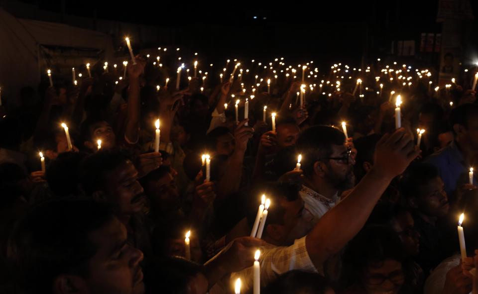 Bangladeshi relatives of victims of last year’s Rana Plaza building collapse, along with activists hold candles during a gathering on the eve of the tragedy, the worst in the history of the garment industry, in Savar, near Dhaka, Bangladesh, Wednesday, April 23, 2014. More than 1,100 people were killed when the illegally constructed, 8-storey building collapsed on April 24, 2013, in a heap along with thousands of workers in the five garment factories in the building. (AP Photo/A.M. Ahad)
