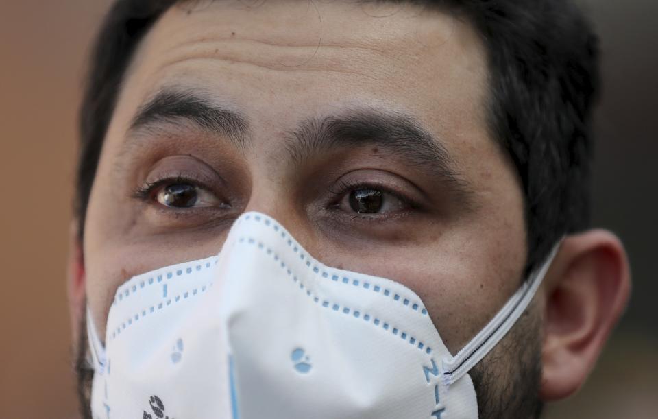 Colombian Dr. Camilo Rodriguez speaks during an interview in Bogota, Colombia, Thursday, Oct. 22, 2020. Rodríguez said he arrives to work in one uniform and changes into another when he treats COVID-19 patients. He lost a close friend and mentor to the virus and fears spreading it to his family. (AP Photo/Fernando Vergara)