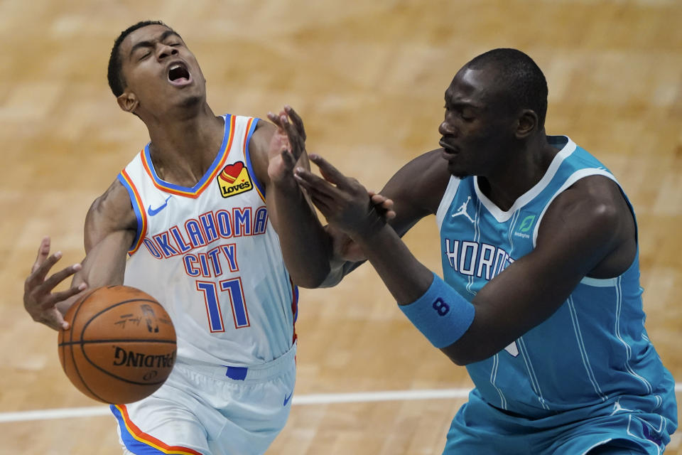 Charlotte Hornets center Bismack Biyombo, right, blocks a shot by Oklahoma City Thunder guard Theo Maledon during the first half of an NBA basketball game in Charlotte, N.C., Saturday, Dec. 26, 2020. (AP Photo/Chris Carlson)
