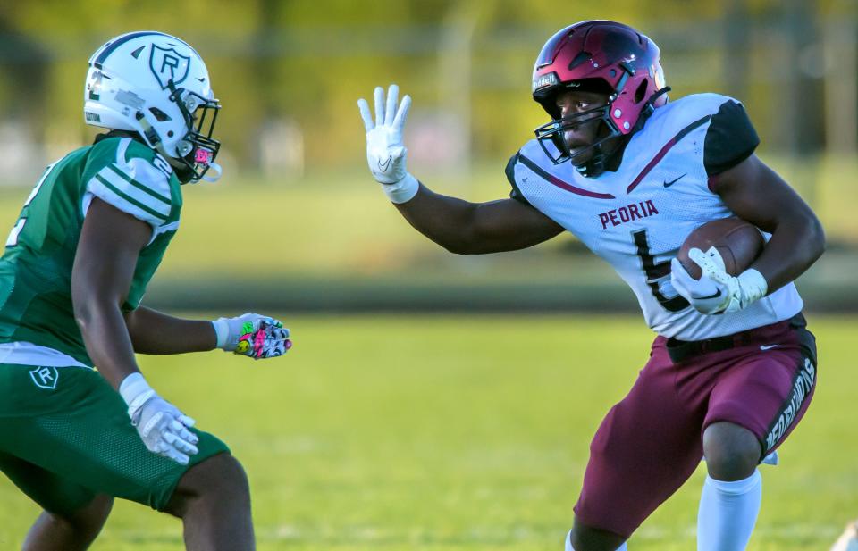 Peoria High's Malachi Washington, right, fends off Richwoods' Kaizon Davis in the first half Thursday, Sept. 29, 2022 at Richwoods Stadium in Peoria. The Knights fell to the Lions 66-12.