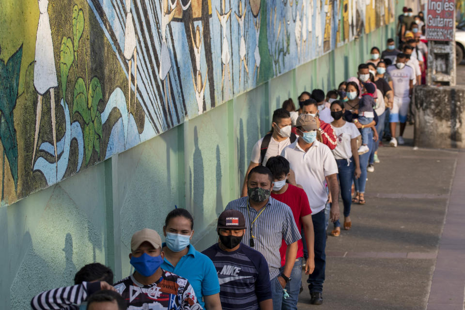 Voters line up at a polling station during a presidential runoff election in Guayaquil, Ecuador, Sunday, April 11, 2021. (AP Photo/Angel Dejesus)