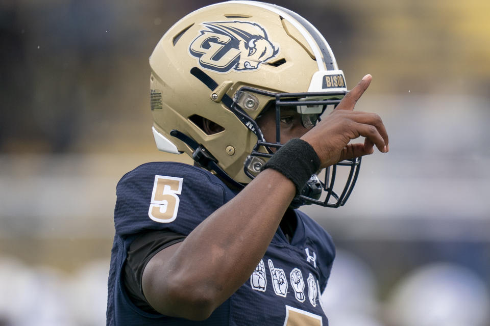 Gallaudet quarterback Brandon Washington runs toward teammates on the bench after scoring a touchdown while wearing a football helmet developed by Gallaudet University with AT&T for Deaf and hard-of-hearing players during an NCAA college football game against Hilbert College, Saturday, Oct. 7, 2023, in Washington. (AP Photo/Stephanie Scarbrough)