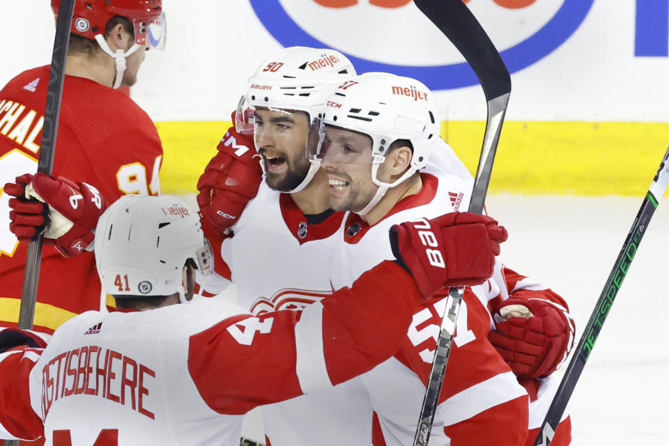 Detroit Red Wings' David Perron, right, celebrates with teammates after scoring a goal against the Calgary Flames during the second period of an NHL hockey game in Calgary, Alberta, Saturday, Feb. 17, 2024. (Larry MacDougal/The Canadian Press via AP)