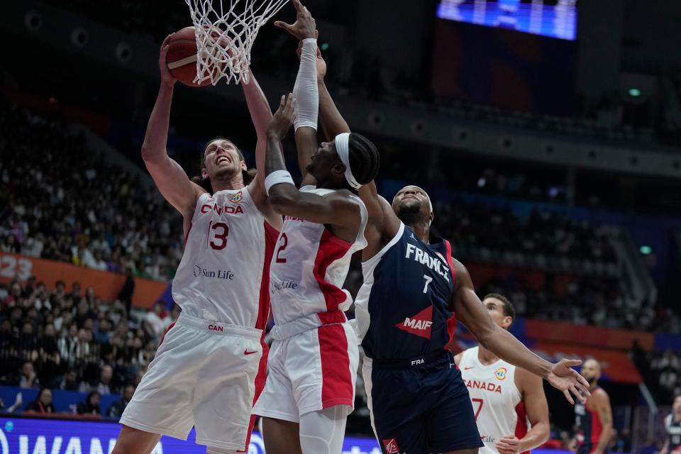 France forward Guerschon Yabusele (7) passes around Canada forward Melvin Ejim (3) and Canada guard Shai Gilgeous-Alexander (2) during the FIBA World Cup on Friday at Indonesia Arena stadium in Jakarta, Indonesia.