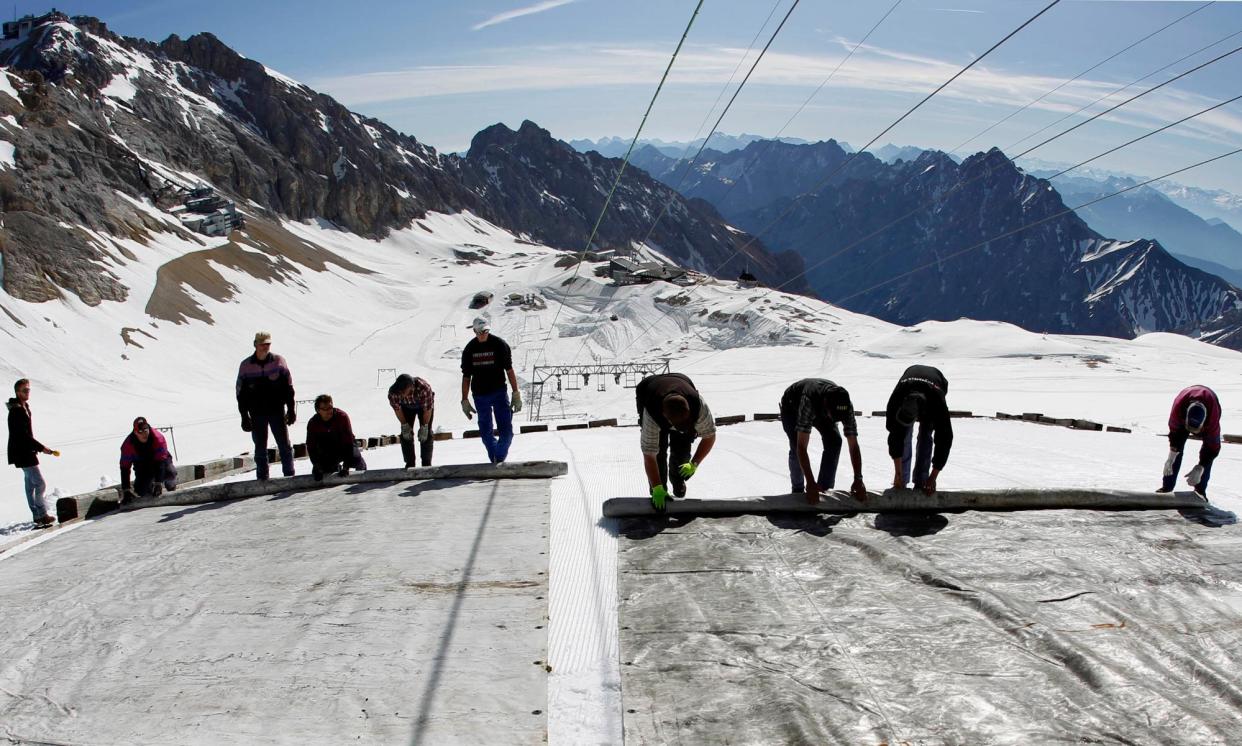 <span>Workers cover a glacier with plastic sheets on the peak of Zugspitze mountain in Germany, May 2011.</span><span>Photograph: Matthias Schräder/AP</span>