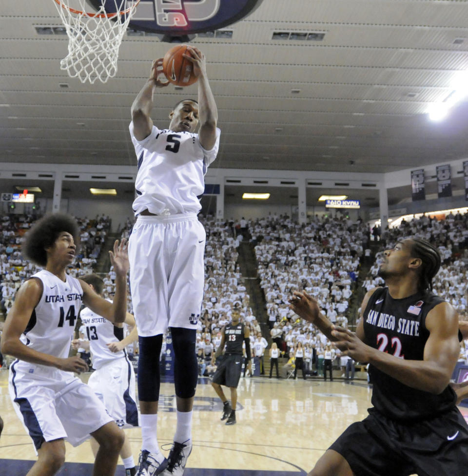 Utah State center Jarred Shaw (5) grabs a rebound over teammate Jalen Moore (14) and San Diego State forward Josh Davis (22) during the first half of an NCAA college basketball game Saturday, Jan. 25, 2014, in Logan, Utah. (AP Photo/Eli Lucero)