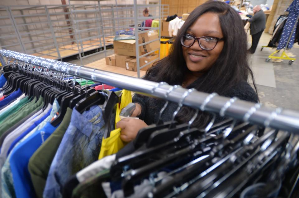 Dashaya Wofford, 22, tags clothing at the AMVETS Thrift Store in Erie on Thursday.