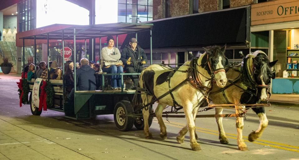 A horse and wagon take people for a ride on Saturday, Nov. 26, 2022, at Stroll on State in Rockford.