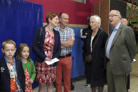 Belgian King Albert II and Queen Paola wait in the queue to cast their vote for the European Parliament and Belgium general elections in Brussels May 25, 2014. REUTERS/Eric Vidal