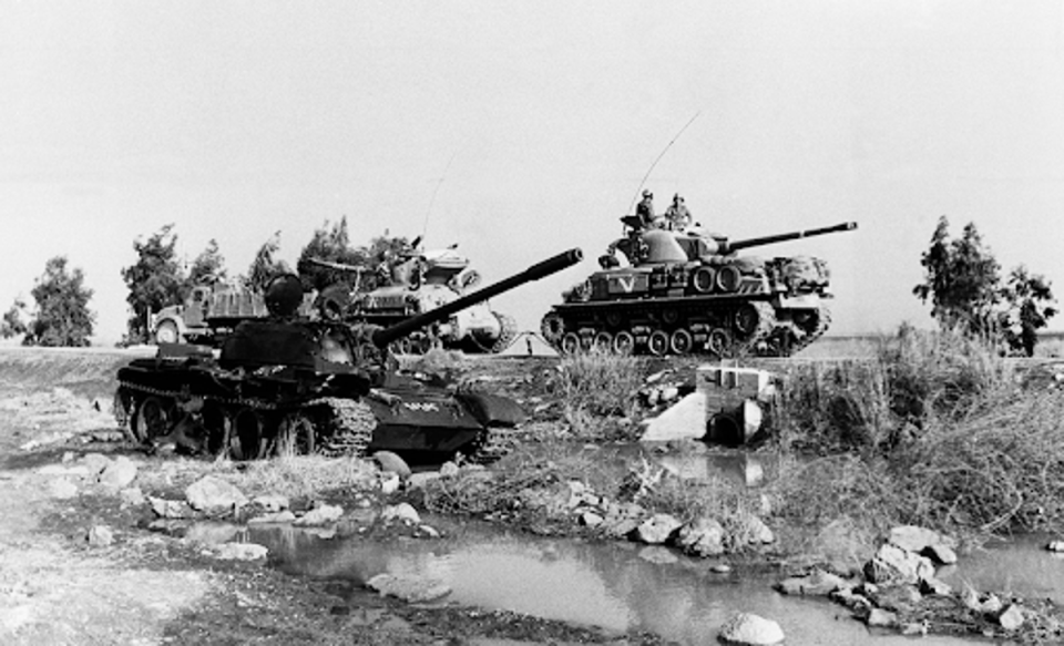 Israeli tanks pass a wrecked Syrian tank, foreground, in the Golan Heights on Oct. 9, 1973. (AP)