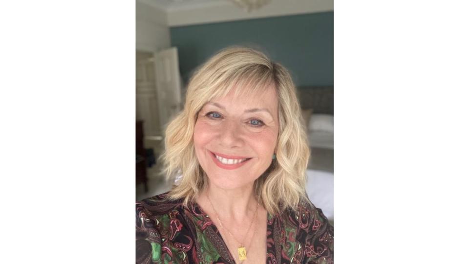 woman smiling wearing a dark printed shirt