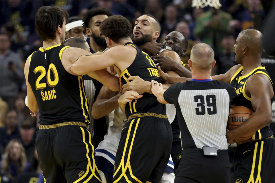 Golden State Warriors' Klay Thompson, front, and Draymond Green, back, get into an altercation with Minnesota Timberwolves center Rudy Gobert, middle, during the first half of an in-season NBA tournament basketball game in San Francisco, Tuesday, Nov. 14, 2023. All three were ejected. (AP Photo/Jed Jacobsohn)