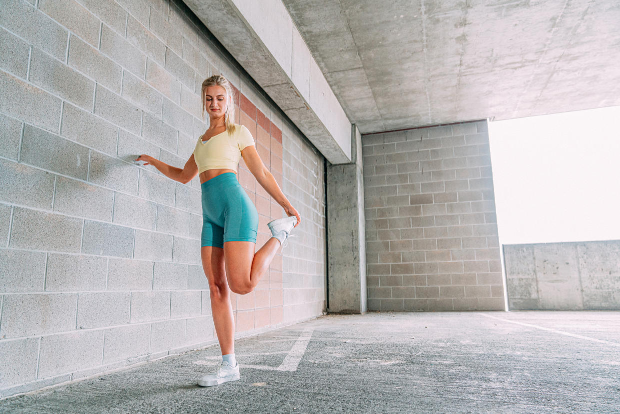 Beautiful Young Blond Woman in Trendy Form-Fitting, Pastel-Colored Active Wear or Jogger Clothing Preparing for a Workout