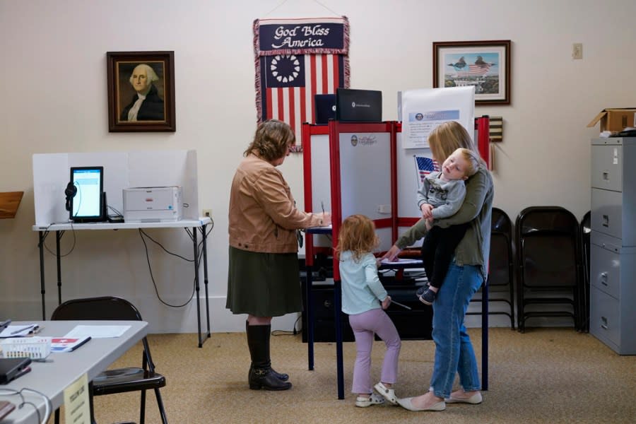 Lauren Miracle, right, holds her son Dawson, 1, as she helps her daughter Oaklynn, 3, fill out a child’s practice ballot before voting herself at a polling location in the Washington Township House in Oregonia, Ohio, Tuesday, Nov. 7. Polls are open in a few states for off-year elections that could give hints of voter sentiment ahead of next year’s critical presidential contest. (AP Photo/Carolyn Kaster)