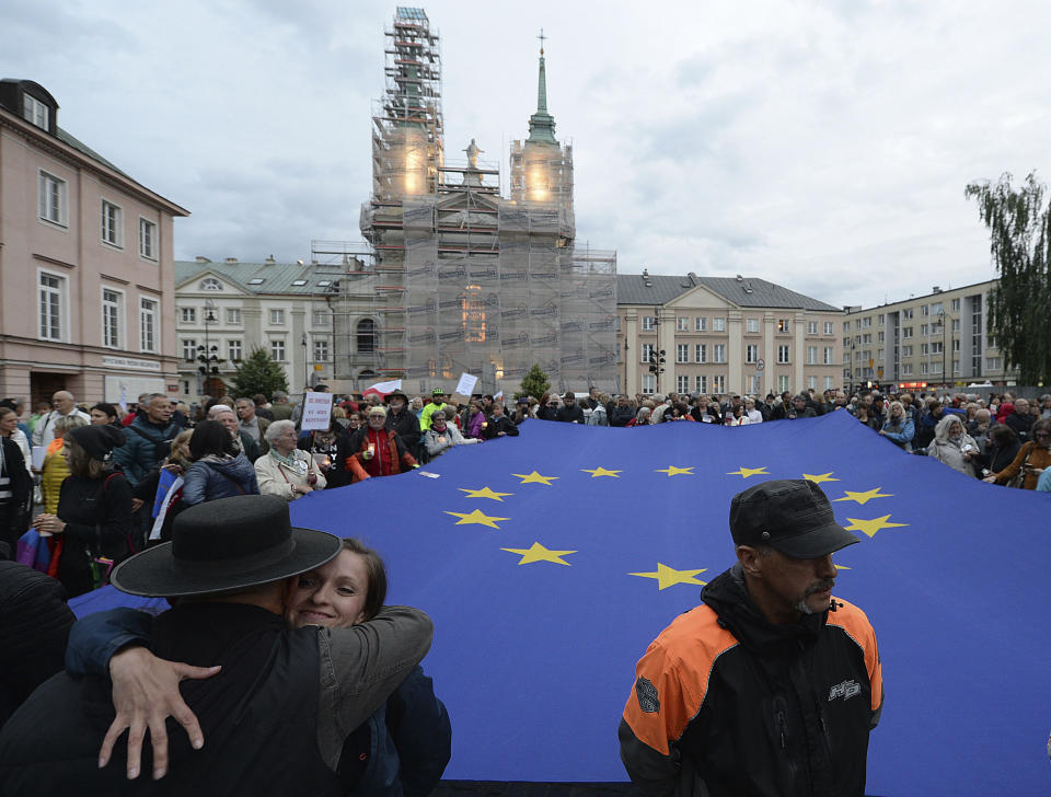 FILE - In this July 2, 2018 file photo, protesters carry an EU flag at an anti-government protest in Warsaw, Poland. Some Poles are afraid that a drawn-out conflict with the EU over the next budget and values could put them on a path toward an eventual departure from the bloc, or "Polexit." Poland's conservative government denies that it has ever wanted to leave the 27-member bloc and popular support for EU membership runs very high. But critics fear the combative tone of some Polish leaders could create momentum which could accidently bring the nation to the exit door. (AP Photo/Czarek Sokolowski, File)