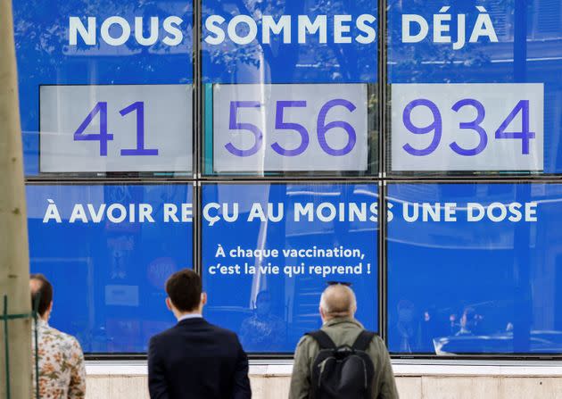 People look at screens showing live the number of French people who received at least a first dose of a vaccine against the Covid-19 on a facade of the Solidarity and Health Ministry in Paris, on July 30, 2021. - 50% of the French population is now fully vaccinated. (Photo by Ludovic MARIN / AFP) (Photo by LUDOVIC MARIN/AFP via Getty Images) (Photo: LUDOVIC MARIN via Getty Images)