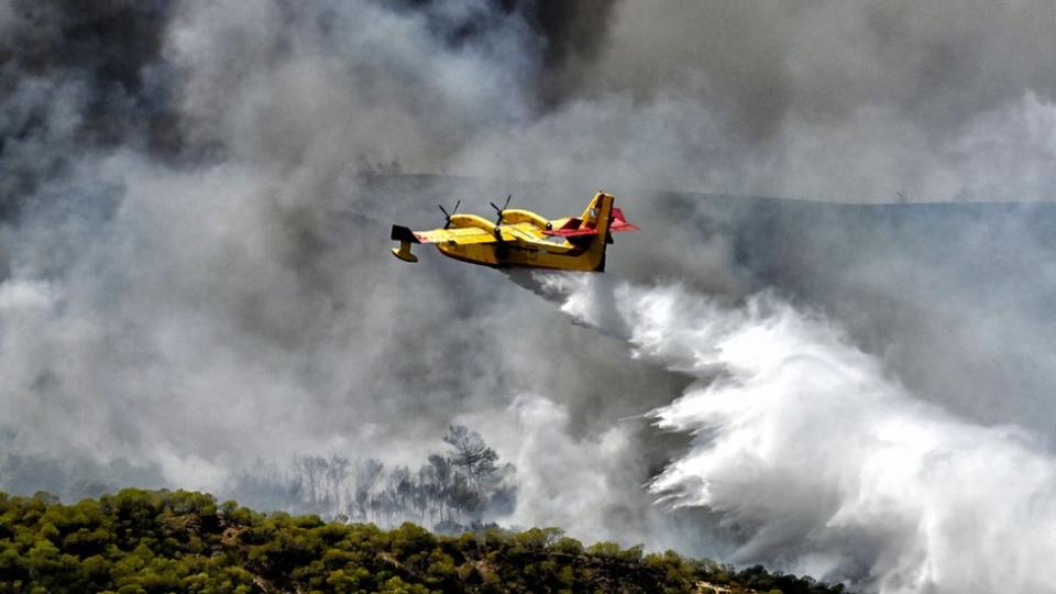 Ένα αμφίβιο αεροσκάφος σχεδιασμένο για εναέρια πυρόσβεση ρίχνει νερό πάνω από δασικές πυρκαγιές στην Ελλάδα