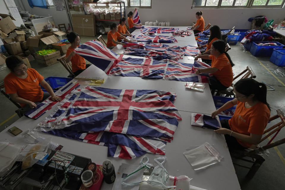 Workers pack British flags produced, at the Shaoxing Chuangdong Tour Articles Co. factory in Shaoxing, in eastern China's Zhejiang province, Friday, Sept. 16, 2022. Ninety minutes after Queen Elizabeth II died, orders for thousands of British flags started to flood into the factory south of Shanghai. (AP Photo/Ng Han Guan)