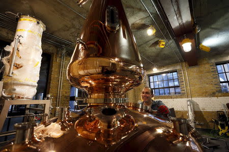 Darren Rook, CEO and Co-founder of The London Distillery Company, smiles after unwrapping a newly delivered still after its arrival from Germany, in London, United kingdom in this February 14, 2013 file photo. REUTERS/Stefan Wermuth/Files