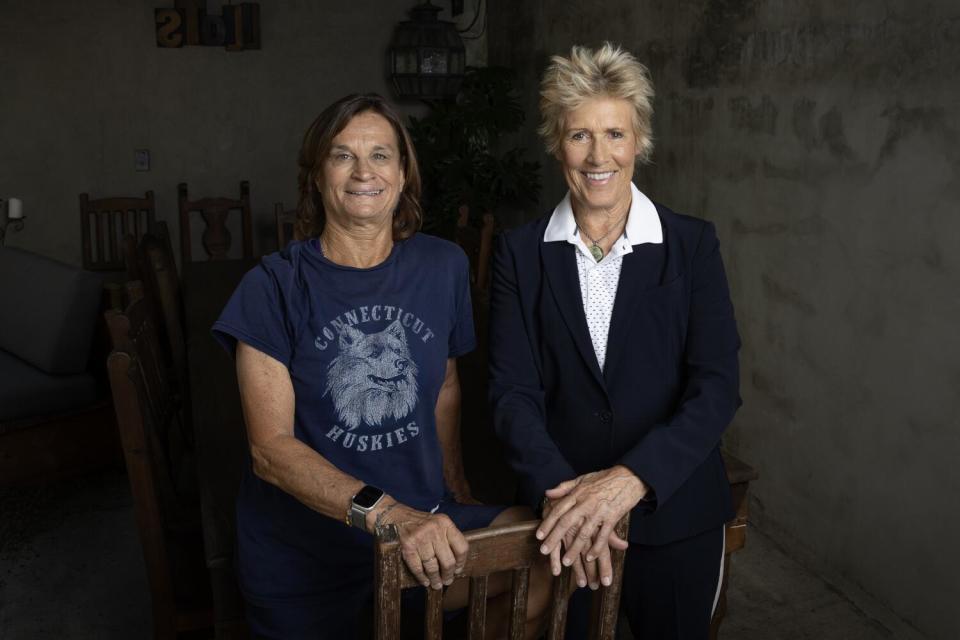 Two women smile and pose for a photograph.