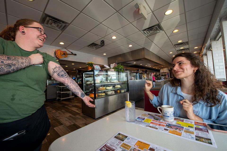 Server Kyra Taylor shows off her latest arm tattoo - a voodoo doll creature - at Round the Clock Diner in Manchester Township.