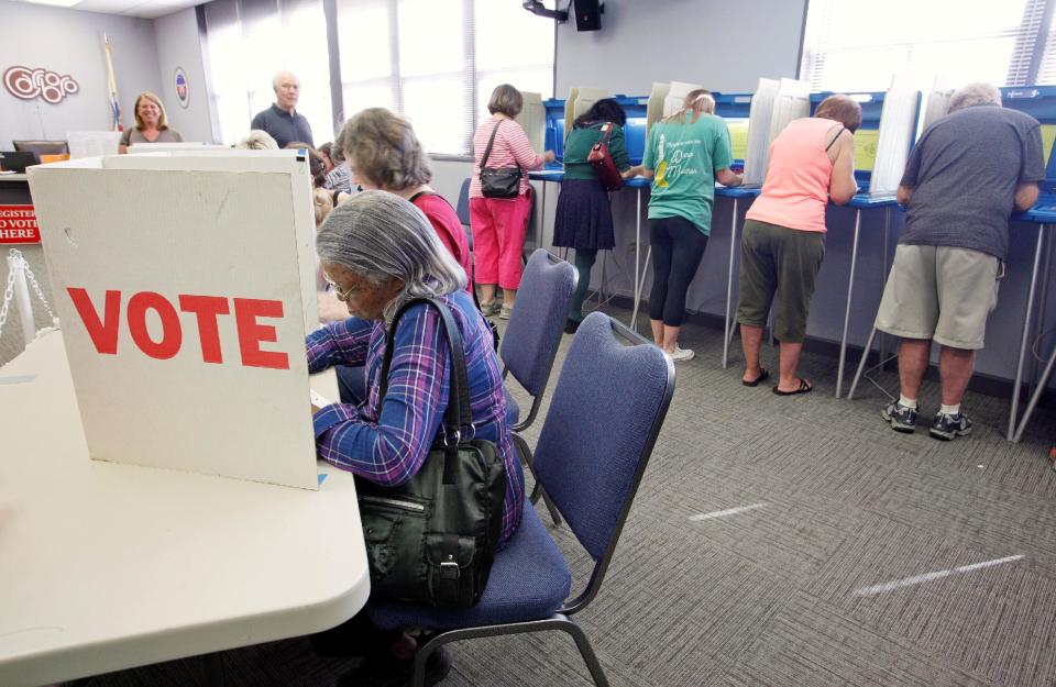 Voters fill in their ballots at a crowded polling station on North Carolina's first day of early voting for the general elections, in Carrboro, North Carolina, October 20, 2016. REUTERS/Jonathan Drake