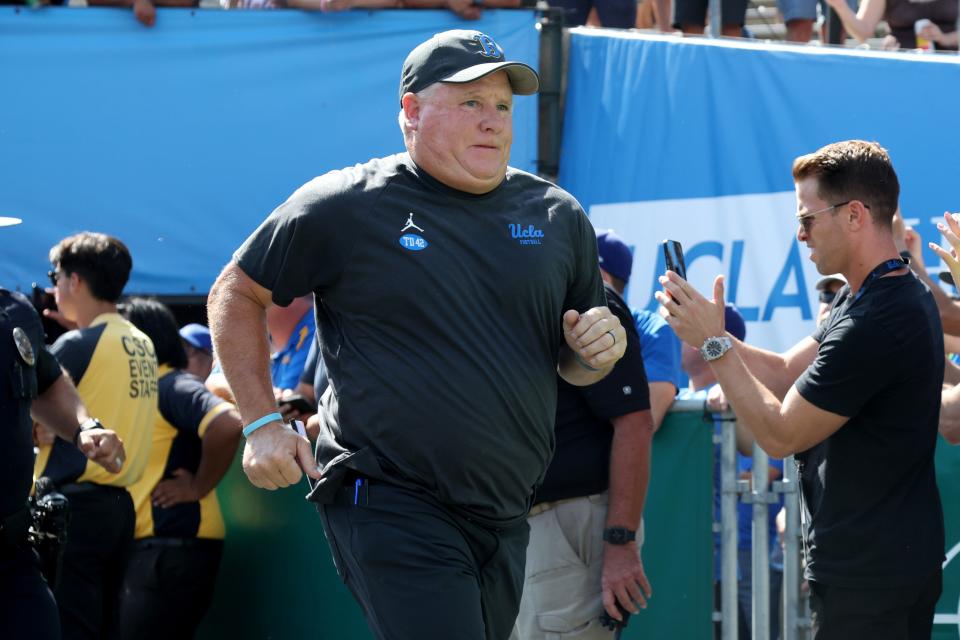 Chip Kelly runs onto the field at the Rose Bowl before a UCLA game against Utah.