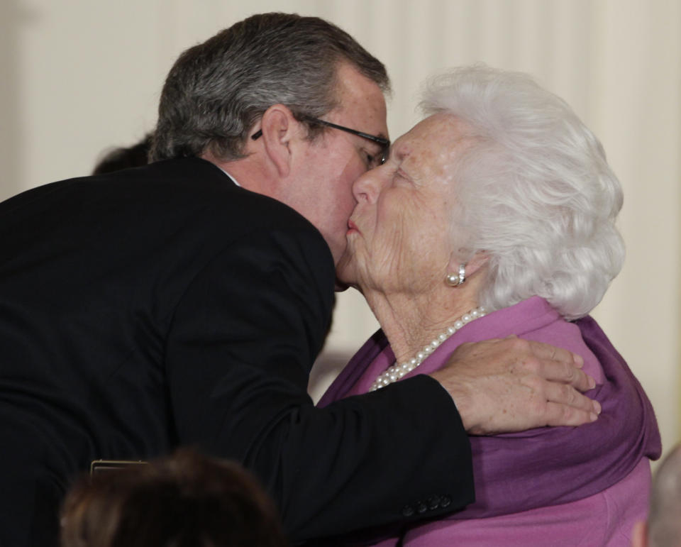 Former first lady Barbara Bush greets her son, former Florida Gov. Jeb Bush, with a kiss as she arrives a the 2010 Presidential Medal of Freedom ceremony, Tuesday, Feb. 15, 2011, in the East Room of the White House in Washington. (AP Photo/Carolyn Kaster)