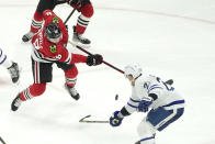 Toronto Maple Leafs' Travis Dermott, right, deflects Chicago Blackhawks' MacKenzie Entwistle's shot on goal with his stick during the second period of an NHL hockey game Wednesday, Oct. 27, 2021, in Chicago. (AP Photo/Charles Rex Arbogast)